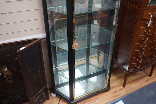 A brass mounted black painted display cabinet with interior lighting, width 92cm, depth 34cm, height 195cm